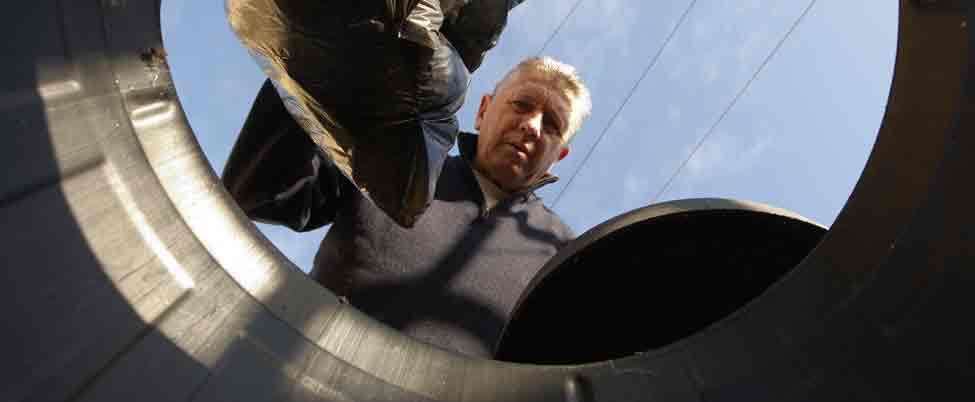 Man putting garbage bag into container