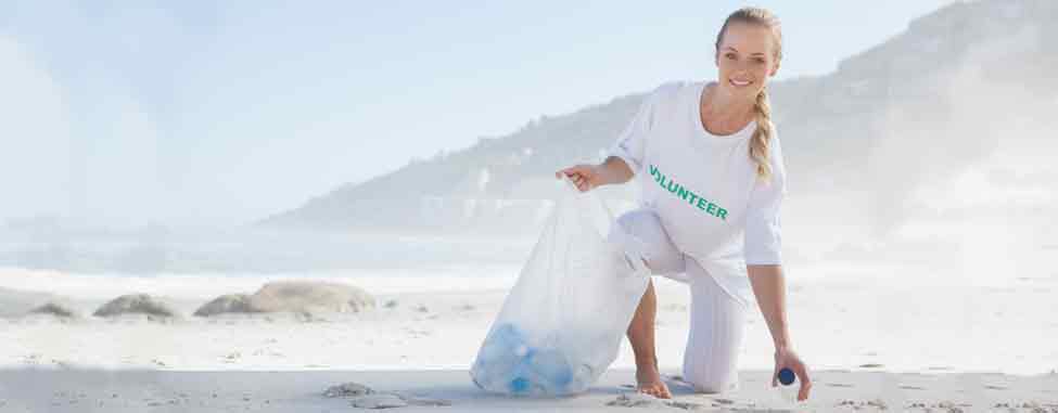 Volunteer picking up trash with clear bag